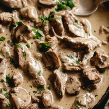 A delicious plate of Beef Stroganoff served with egg noodles and garnished with parsley.