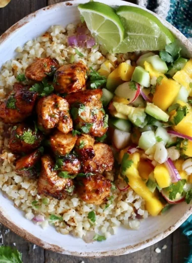 Cilantro Lime Riced Cauliflower and Chicken Bowl on a wooden table.