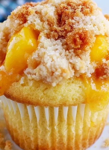 Freshly baked peach cobbler muffins topped with crumble