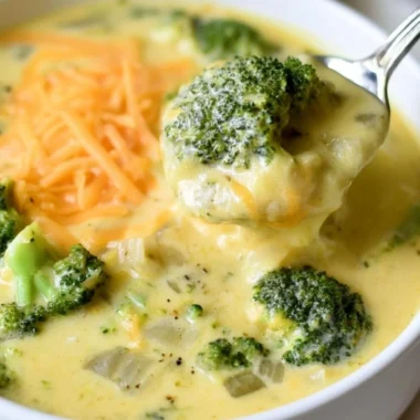 Bowl of creamy keto broccoli cheese soup garnished with fresh herbs