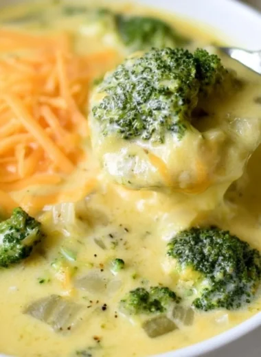 Bowl of creamy keto broccoli cheese soup garnished with fresh herbs