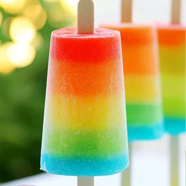 Colorful rainbow popsicles arranged on a white plate