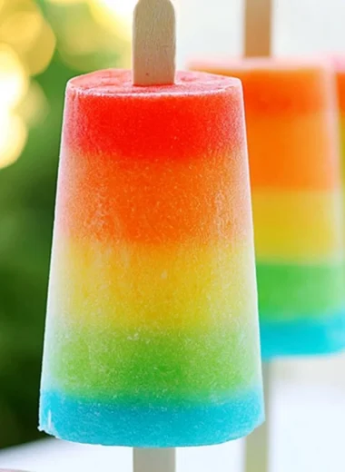 Colorful rainbow popsicles arranged on a white plate