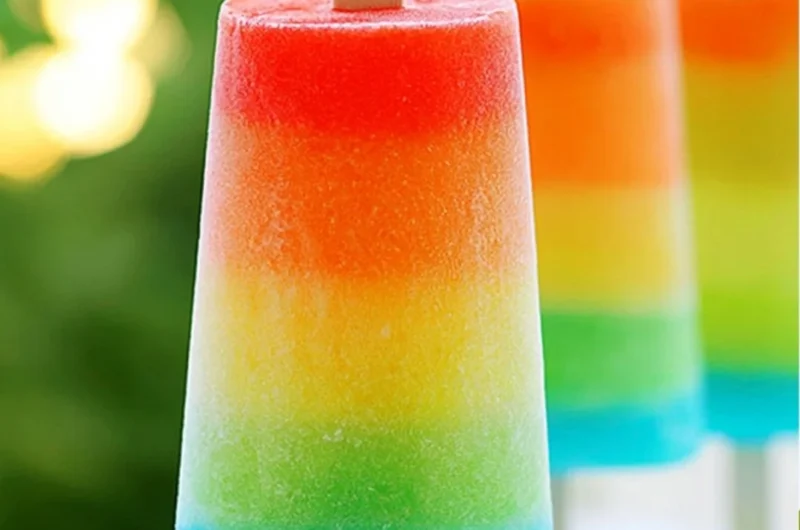 Colorful rainbow popsicles arranged on a white plate