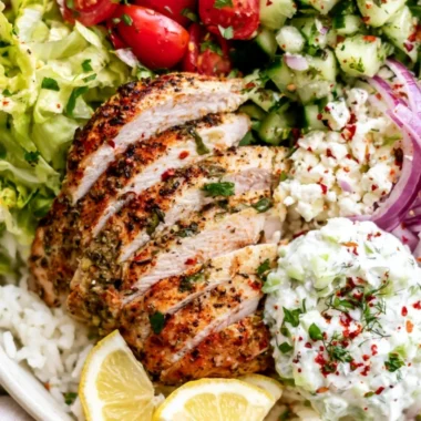Delicious Lemon Herb Greek Chicken Bowls garnished with fresh herbs and vegetables.