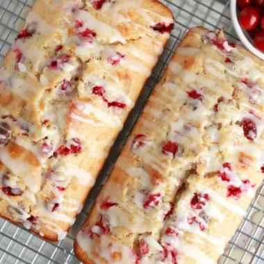 Freshly baked cranberry orange bread loaf with cranberries and orange slices