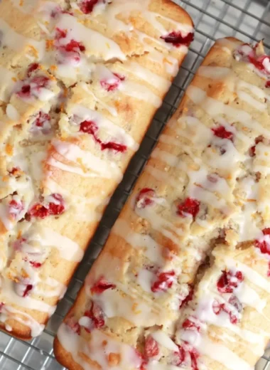 Freshly baked cranberry orange bread loaf with cranberries and orange slices